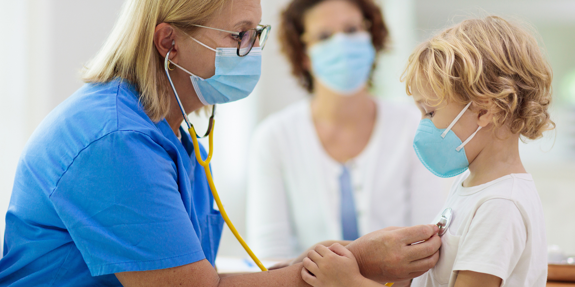 Doctor listening to little boy's heart