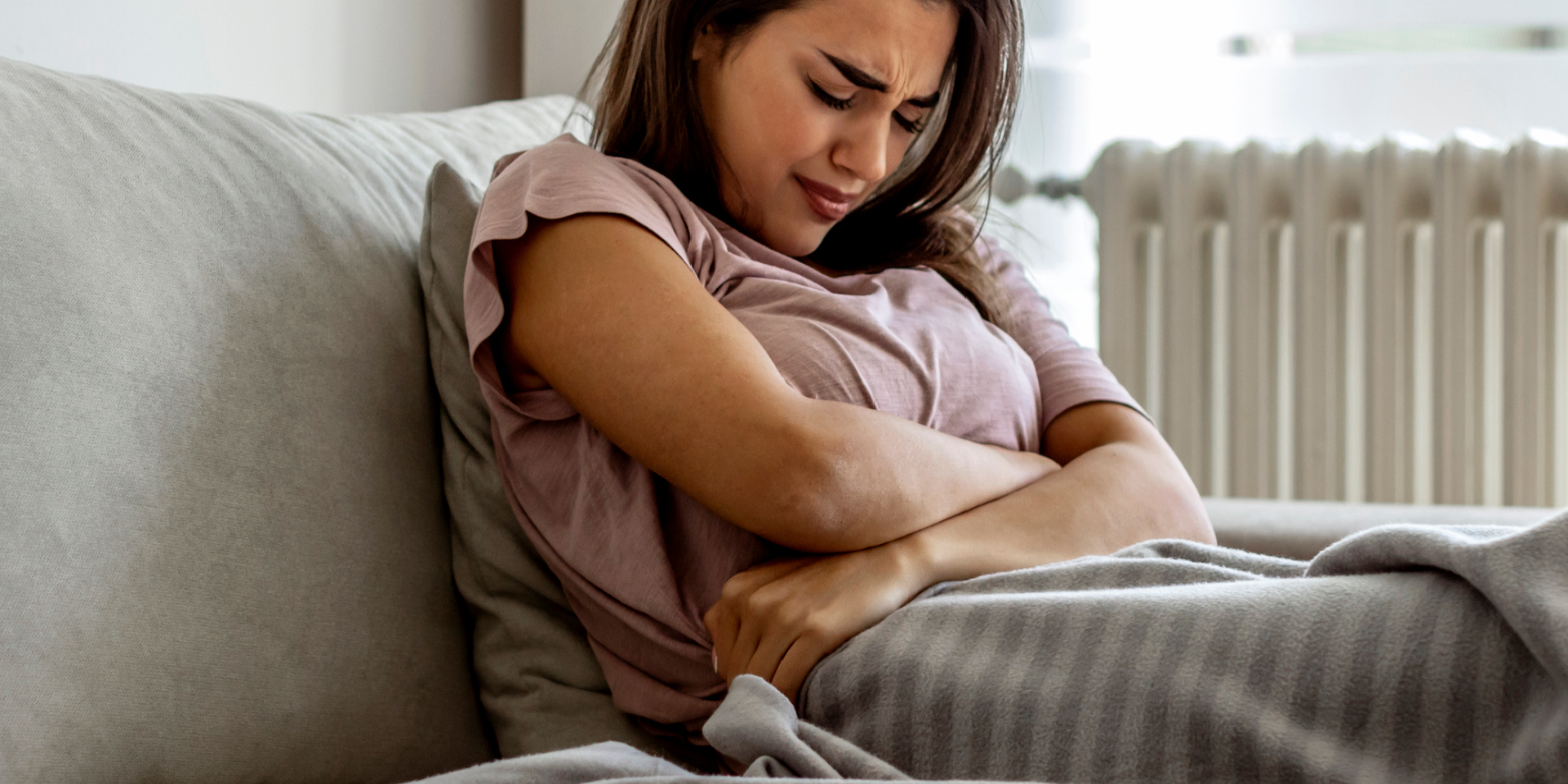 Woman clenching her belly in pain.