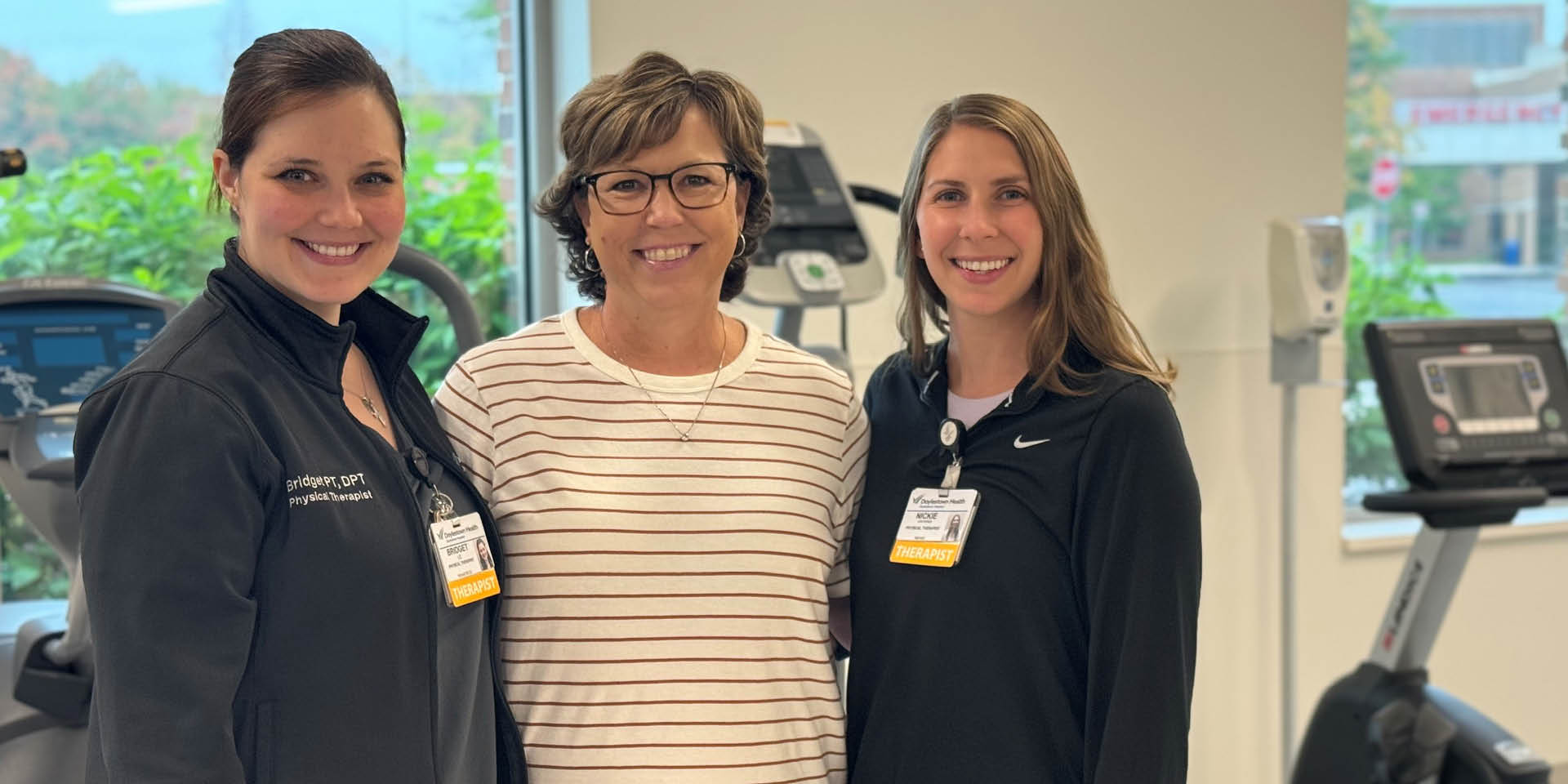 Laurie in the middle of two physical therapists with arms around each other | Doylestown Health