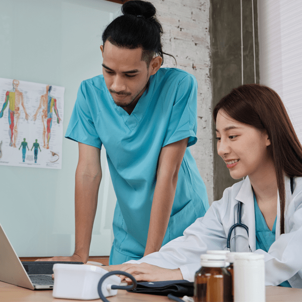 Two uniformed young doctors work in medical clinic office | Doylestown Health
